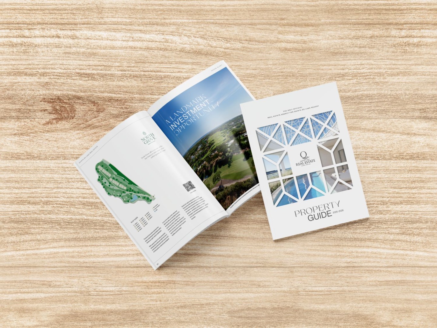 Two Quinta do Lago Property Guide magazines are open and closed on a light wood surface, displaying property information, images, and architectural designs on their covers and pages.