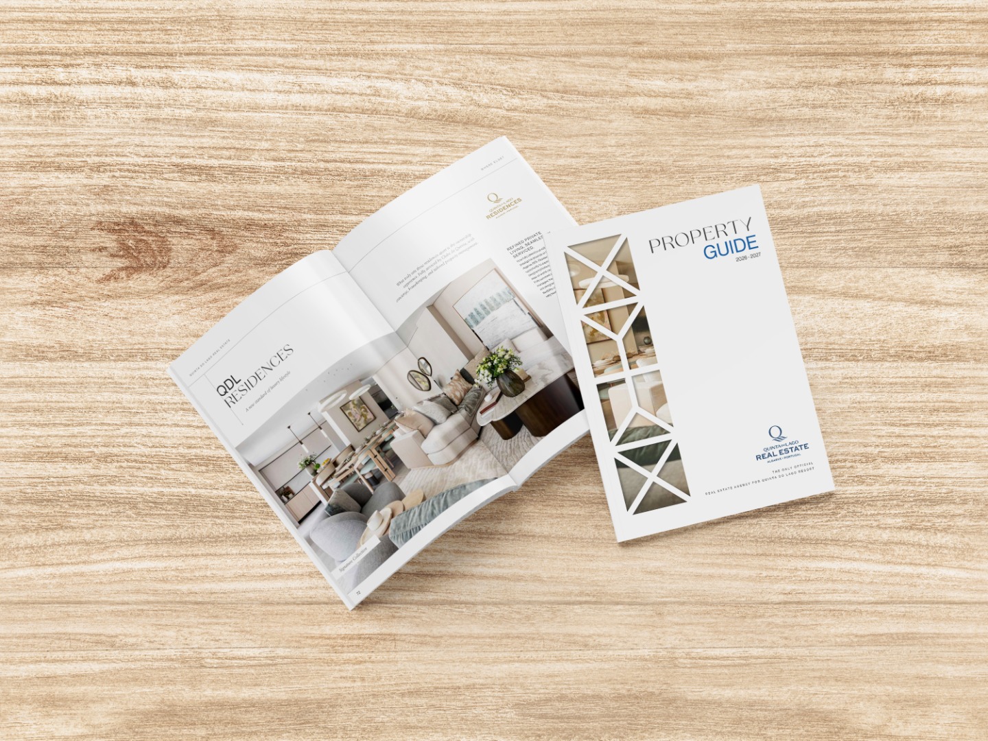 Two Quinta do Lago Property Guide magazines are open and closed on a light wood surface, displaying property information, images, and architectural designs on their covers and pages.